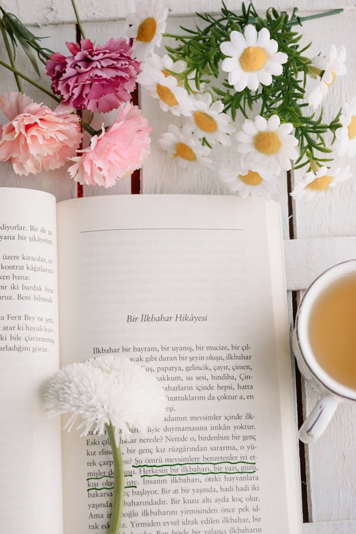 Open book with spring flowers and tea creating a peaceful reading ambiance.